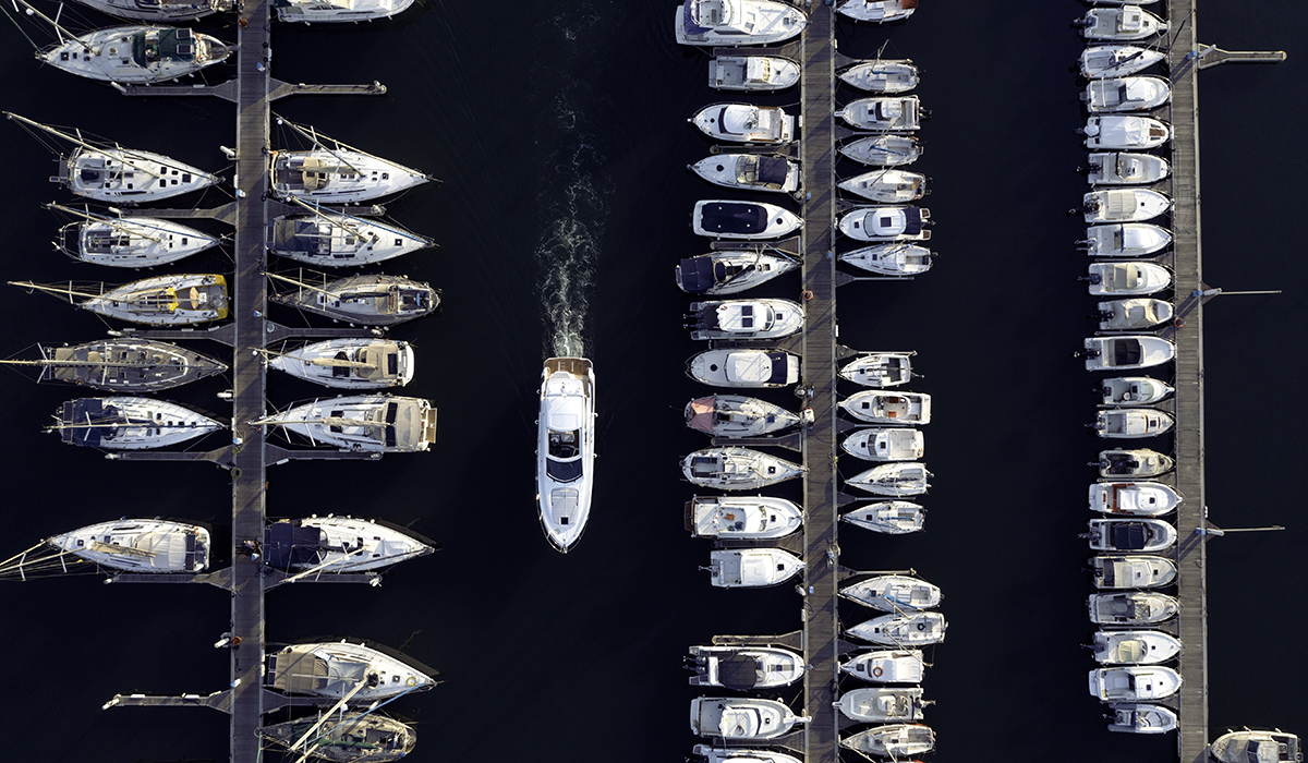 A boat pulling into a full marina.
