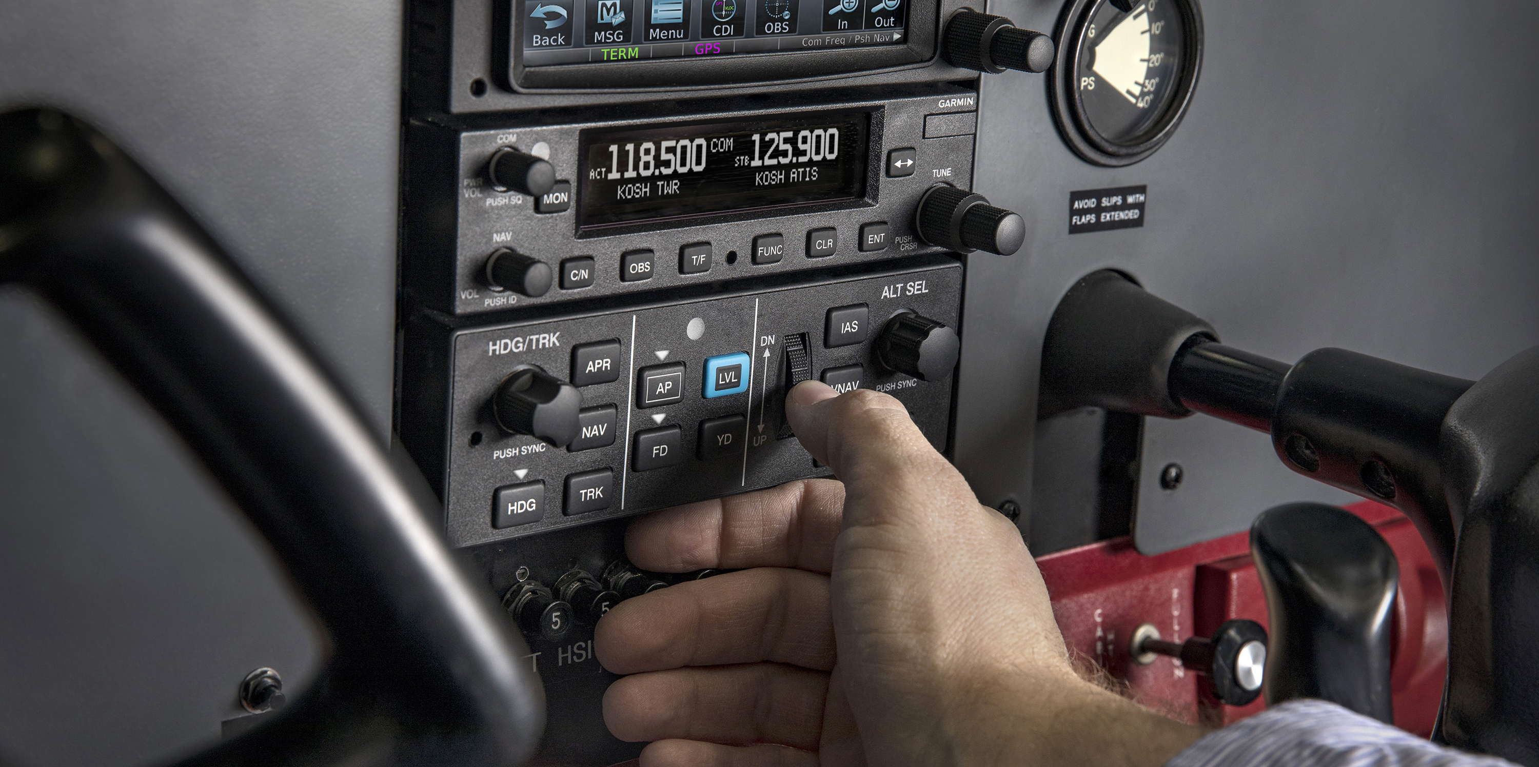 Hand touching GFC 500 mode controller in cockpit