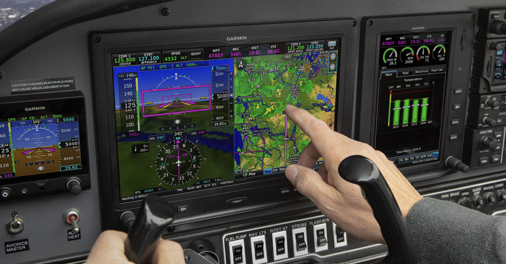Pilot interacting with G3X Touch in cockpit of aircraft