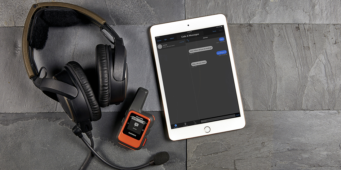 Headset, inReach Mini and iPad with messages displayed on table.