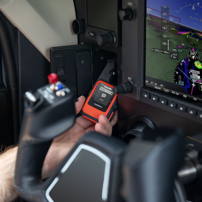 Pilot holding inReach in cockpit with message received notification
