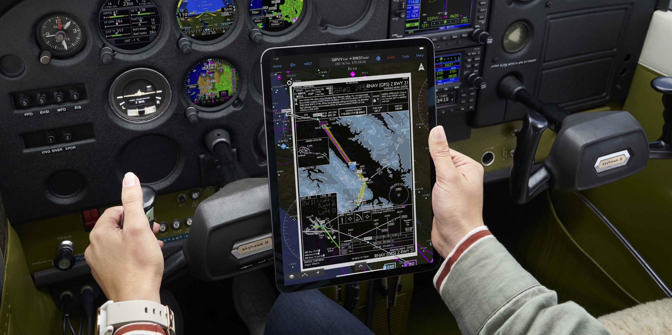 Pilot holding iPad in airplane cockpit
