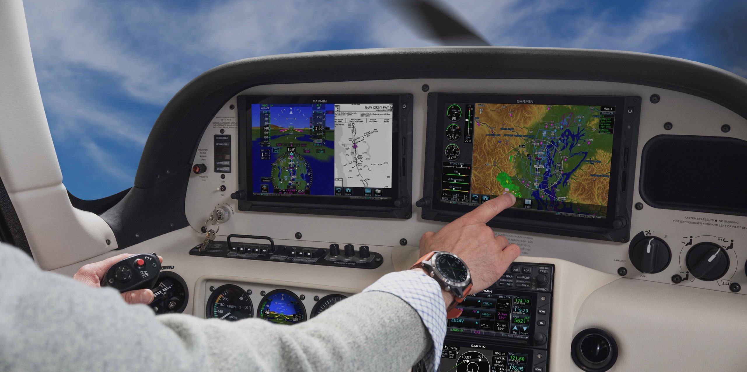 Aircraft cockpit with pilot touching TXi flight display