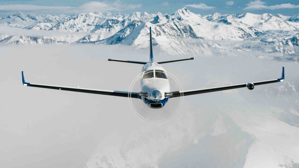 Daher TBM 940 aircraft in-flight with mountains in background