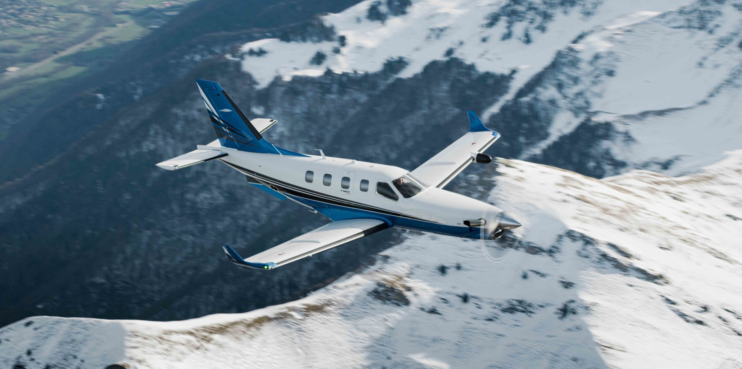 Daher TBM 940 aircraft flying over mountains