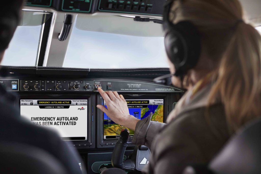 Passenger selecting Autoland button in Piper M600 SLS, Autoland activation screens displayed on G3000