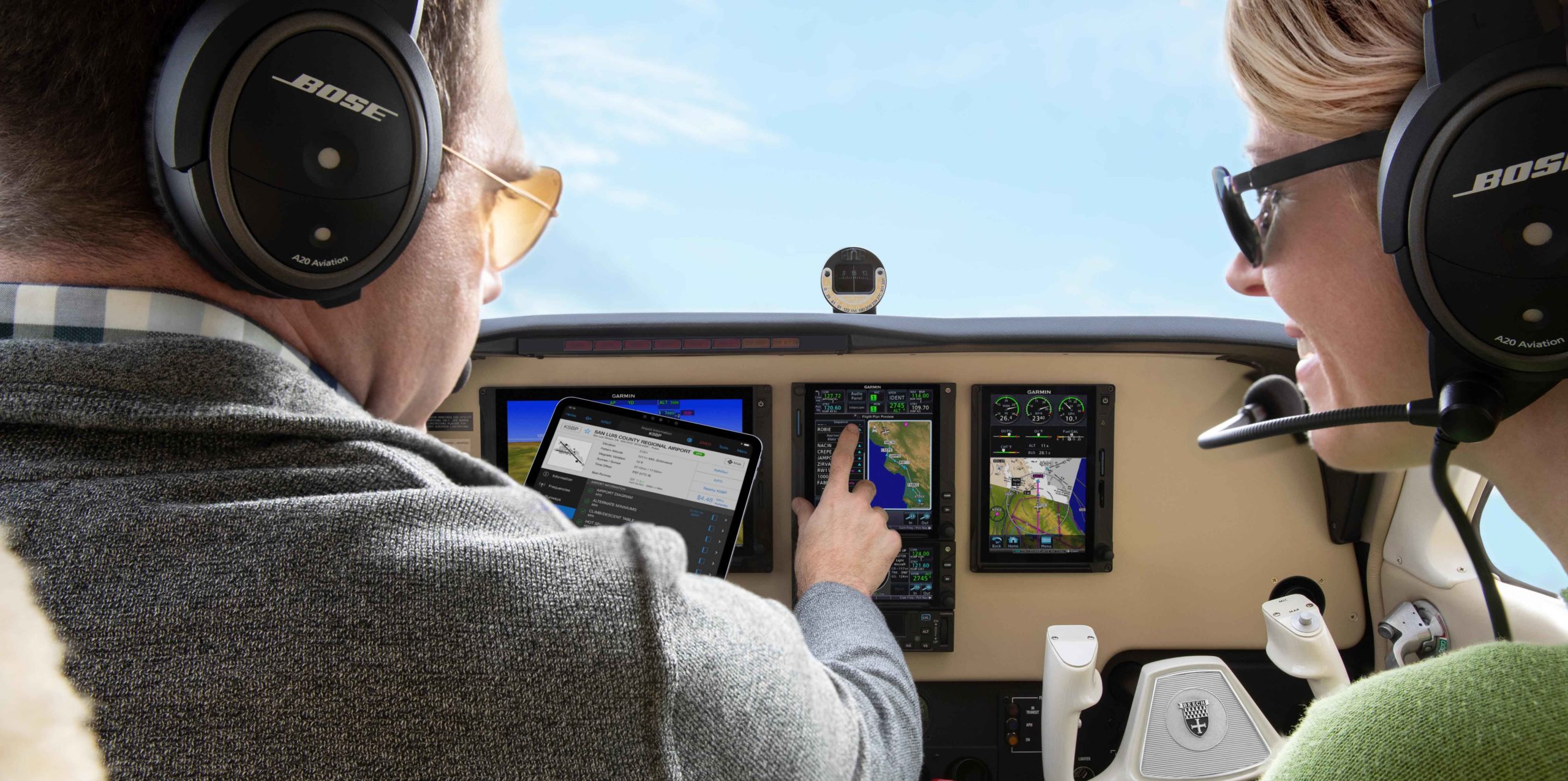 Two pilots in aircraft cockpit interacting with Garmin avionics