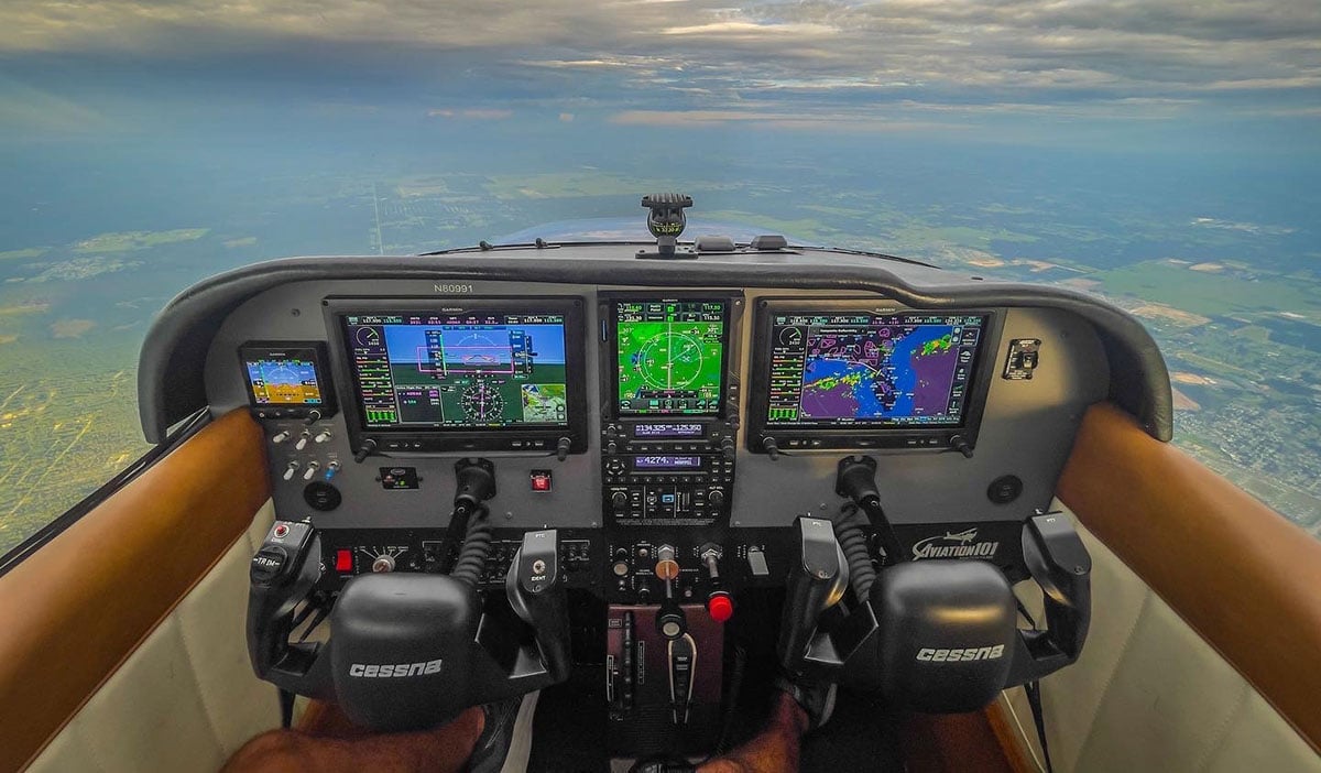 Pilot ineracting with GTN 750Xi in the cockpit of an airplane.