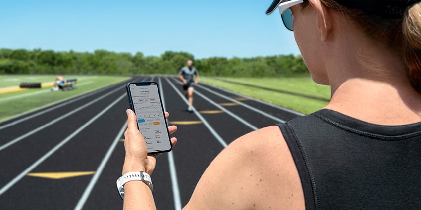 A woman runs with her Garmin smartwatch for safety features