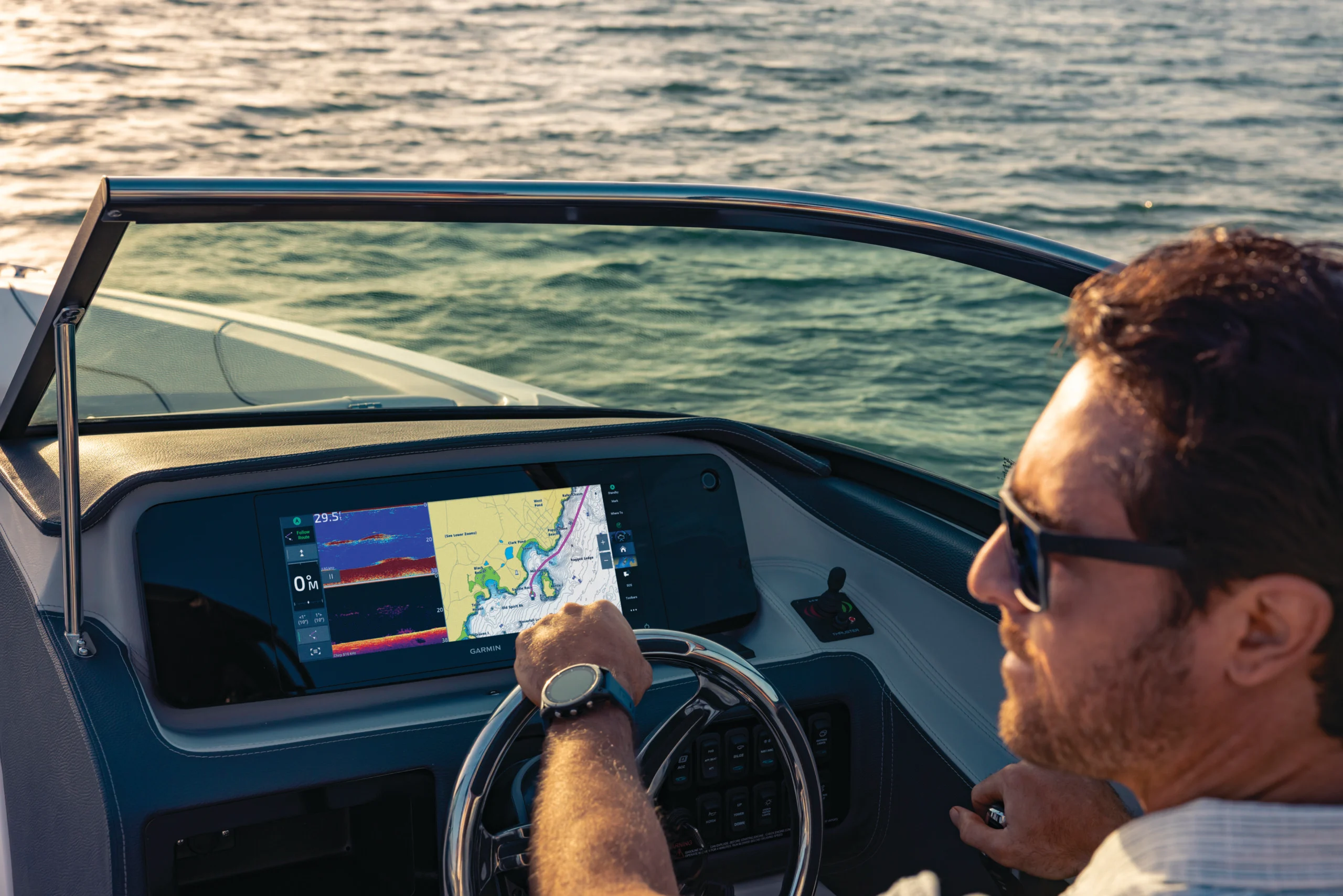Un homme conduit un bateau avec ses écrans de navigation Garmin Marine