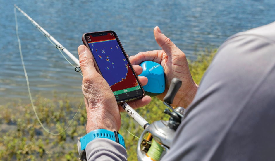 Amatörsportfiskare som håller i mobiltelefon, Garmin Strikercast och fiskespö
